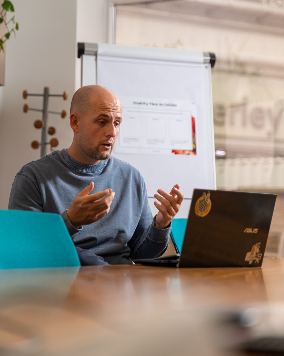 Lee Fitzpatrick gesturing as he speaks at a workshop table
