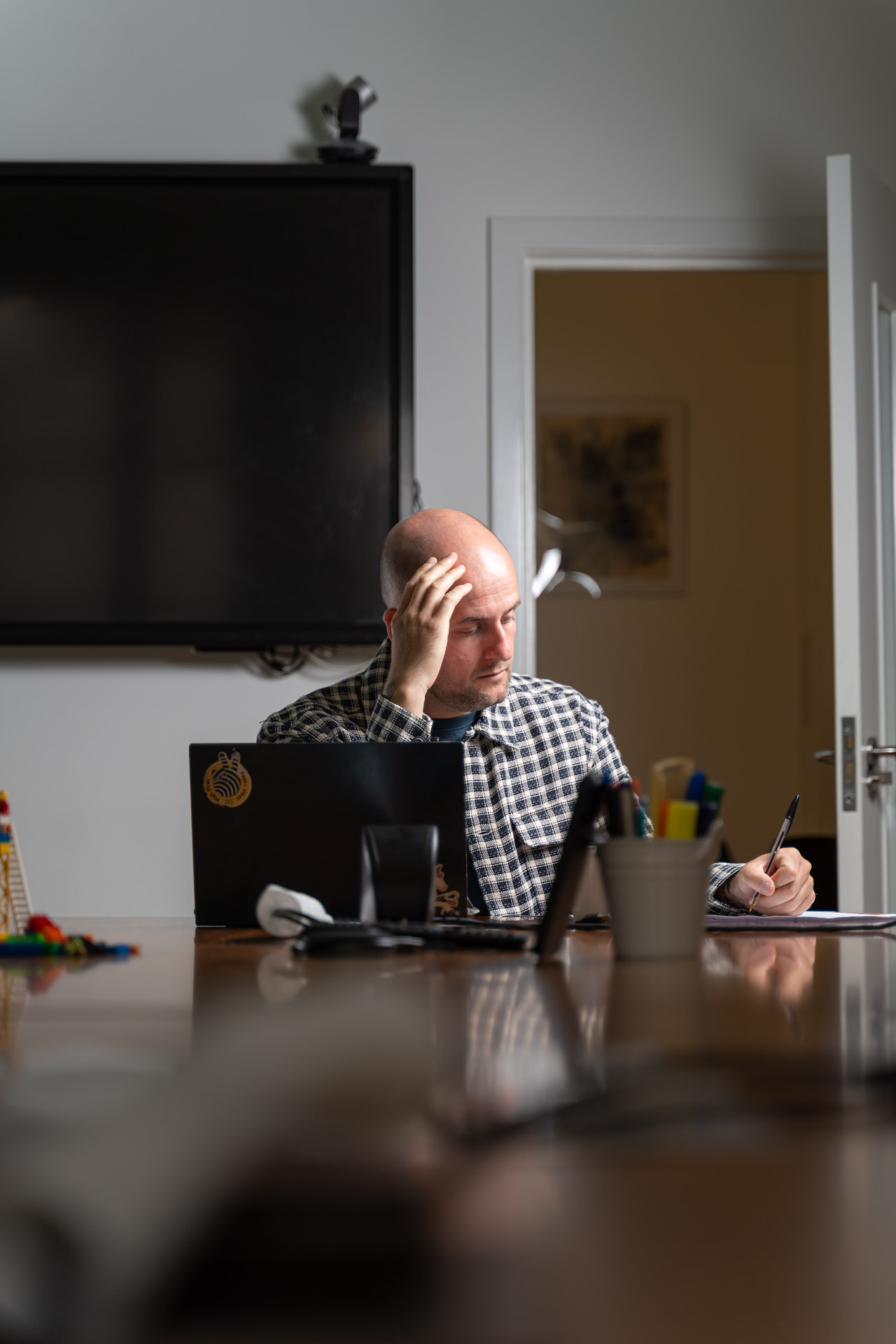 Lee Fitzpatrick considering ideas and making notes at a workshop table