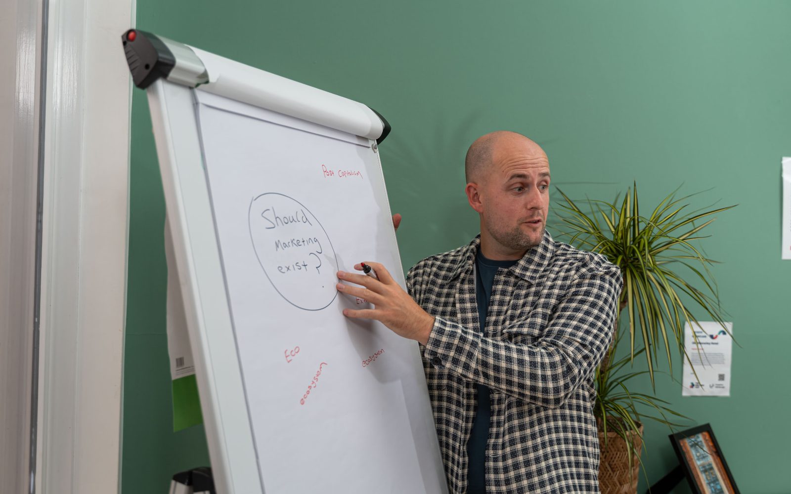 Lee Fitzpatrick facilitating a workshop, marker in hand, beside a flipchart